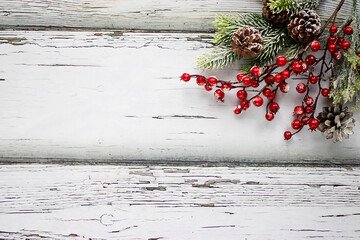 Beautiful decorative green branches with red berries and white snow on old wooden  background. Copy...