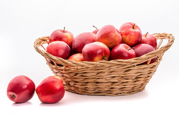 Red apples in a wicker basket. Isolate on white background