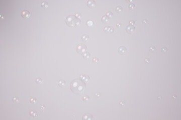 Soap bubbles foamy with rainbow colors on gray background. Water air sphere.