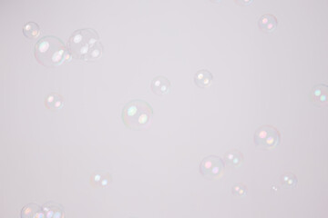 Soap bubbles foamy with rainbow colors on gray background. Water air sphere.
