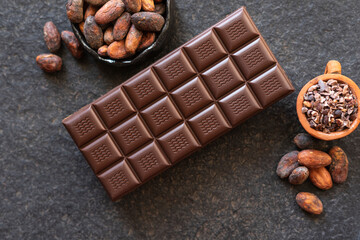 Chocolate, cocoa beans, cocoa slices on a black background
