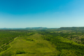 aerial view of area with woods beside highway and mountains in the background - Brazil