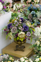 Decorative bouquet of artificial roses, blue white purple fabric flowers in a metal vase, vertical