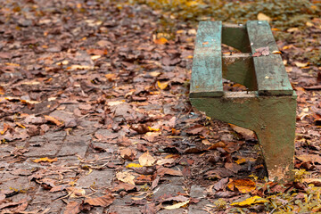 Bancos e mesa de madeira vazios e abandonados dentro de parque 