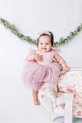 Little girl baby in a beautiful dress with the number 1