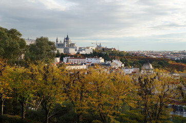 View on Royal Palace of Madrid on the hill with autumn trees in the foreground