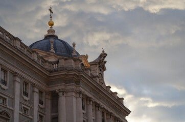 Fototapeta na wymiar Dome with cross of Royal Palace in Madrid with clouds in the background, Spain