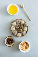 Sweet candy energy balls with nuts, dried fruits and honey on plate flat lay on light background. Vegetarian, organic food.