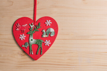 red wooden heart with reindeer figure, isolated on wood
