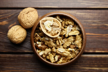 Walnut half and seeds and bowl on wooden table