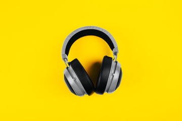 modern gray wired headphones on illuminating background, dj listening to music on headphones. color of year 2021