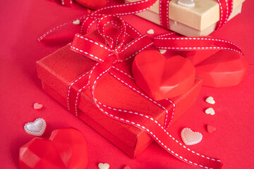 Obraz na płótnie Canvas Valentine greeting card background, with gift box festive ribbons, assorted hearts on red table backdrop top view copy space for text. Valentine's day concept.