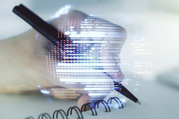 Double exposure of abstract programming language with world map and man hand writing in notebook on background, research and development concept