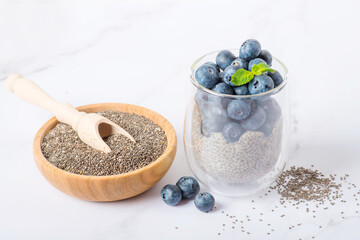 Pudding with chia seeds, granola and fresh blueberry in glass jar