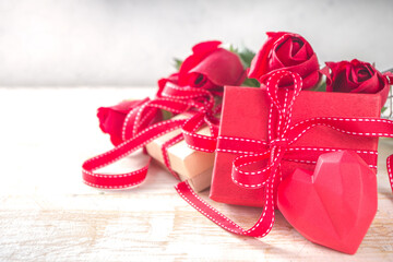 Valentines Day concept, Red Roses and Gift Boxes with Festive Ribbon and Heart Decor on White wooden table background copy space. Romantic floral background.