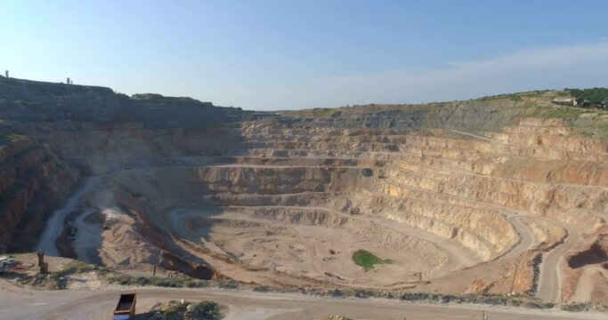 Aerial view of opencast mining quarry with lots of machinery at work - view from above. 