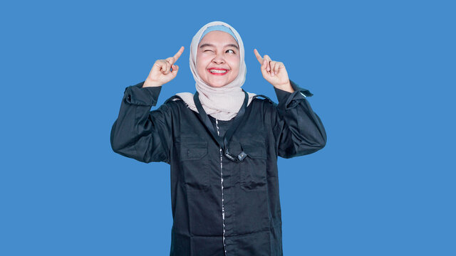 Look Here, Advertise! Portrait Of Asian Woman In Black Suits Showing With Her Hands For Empty Copy Space, Blank Wall For Commercial Idea, Product Image. Indoor Studio Shot Isolated On Blue Background