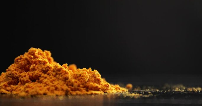 Aromatic turmeric with scoop on dark background
