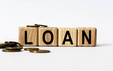 wooden cubes and LOAN, coins, the concept of taxation, increase taxes and fees