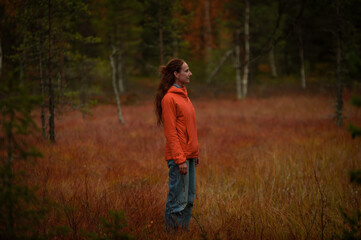 woman in a red meadow in the autumn forest