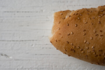 Fresh bread sliced baguette on rustic white table top view