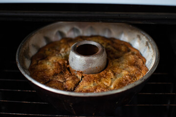 Delicious apple pie with cinnamon in metal mold in oven in kitchen