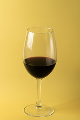 glass of red wine on a yellow