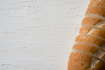 Fresh bread sliced baguette on rustic white table top view