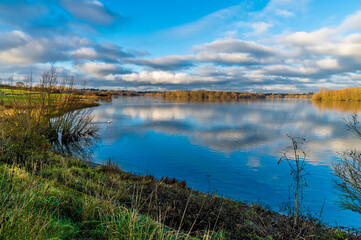 A view of clouds reflected in waters of the northern section of Pitsford Reservoir, UK in winter