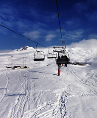 Chair-lift and off-piste slope in sun day