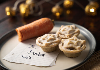 Composition of a carrot and yummy mince pies with a note 