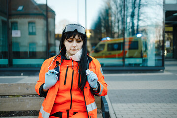 Smiling female paramedic with lowered respirator looks at you