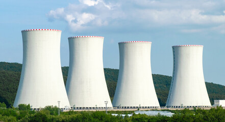 Nuclear power plant. Cooling towers on the background of blue sky and mountains