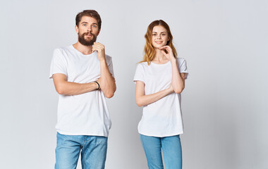 a man and a woman in jeans and a T-shirt on a light background gesturing with hands portrait friends family