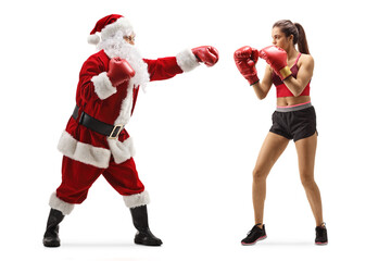 Full length profile shot of a young female boxer and santa claus punching with boxing gloves