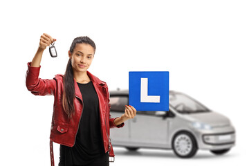 Female driver with a urban car holding a key and a learner plate