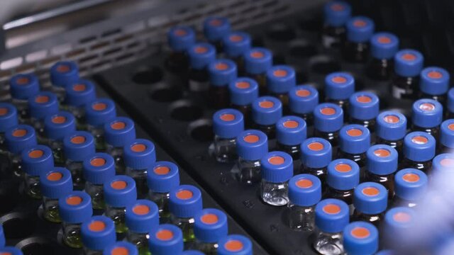 Scientist puts samples into auto sampler for HPLC analysis. Testing of vaccine against coronavirus. Process of work with medical samples.