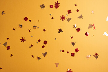 Christmas sparkles in the form of a Christmas tree, gifts, stars on a yellow background. High quality photo