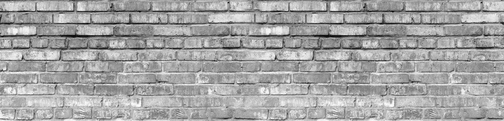 Fototapeta premium Grunge Ultimate Grey Brick Wall Background Large Banner. Aged Gray Wall Texture. Distressed Urban City Brickwork. Grungy Black White Stonewall Wide Wallpaper.