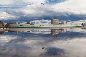 Old soviet submarine in port reflected in puddle