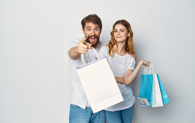 Young couple in white T-shirts with packages in their hands shopping joy