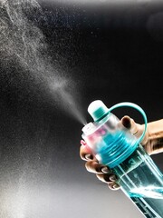 water is sprayed from the blue bottle