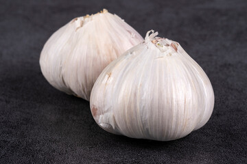 Closeup of Two Bulbs of New White Garlic on Grey Textured Background
