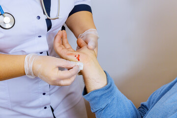 Visiting doctor wipes the blood on the injured hand