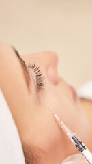 Near eye injection at spa salon. Doctor hands. Closeup. High quality. Pretty female patient. Beauty...