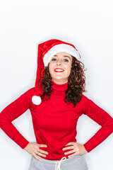 A beautiful brunette woman wearing a red sweater and a Santa hat smiling at the camera. Christmas woman portrait concept.