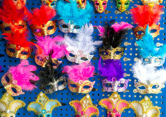 Various, colourful Venetian masks with feathers, souvenirs