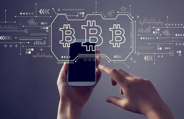 Bitcoin theme with person holding a white smartphone