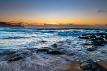 Obraz premium Sunrise seascape with light cloud, waves and rocks