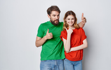 funny man and woman in multicolored t-shirts emotions hand gestures friendship